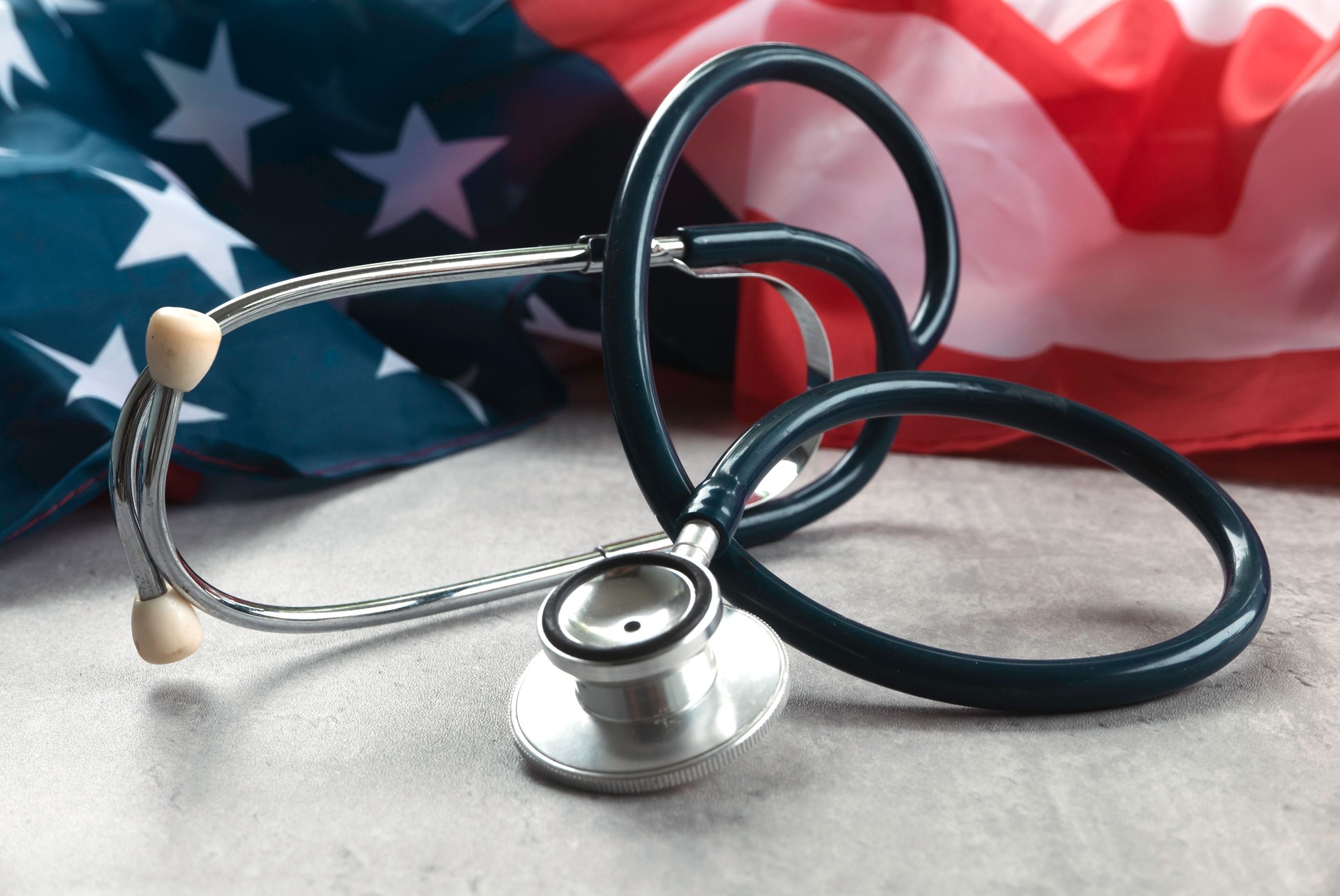 Bandeira e estetoscópio dos EUA representando cuidados de saúde e serviços médicos nos Estados Unidos